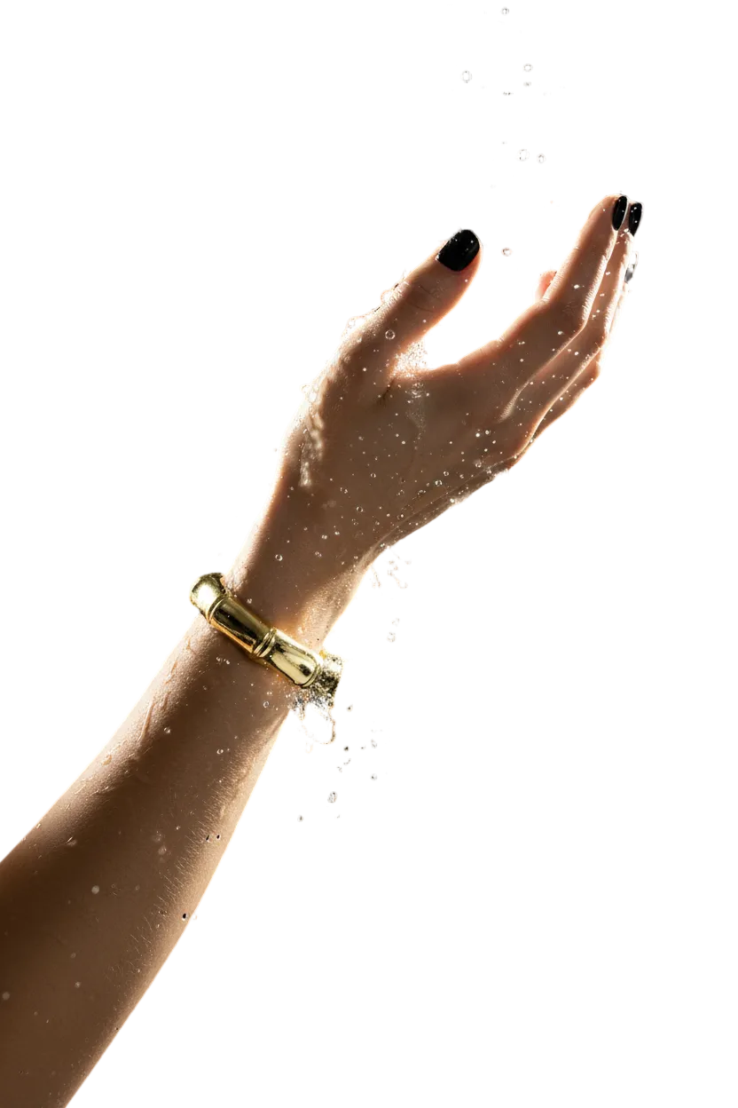 Belle jeune femme qui jette de l'eau sur le bracelet bambou doré