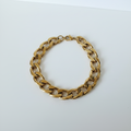 Bracelet chaîne dorée sur fond blanc